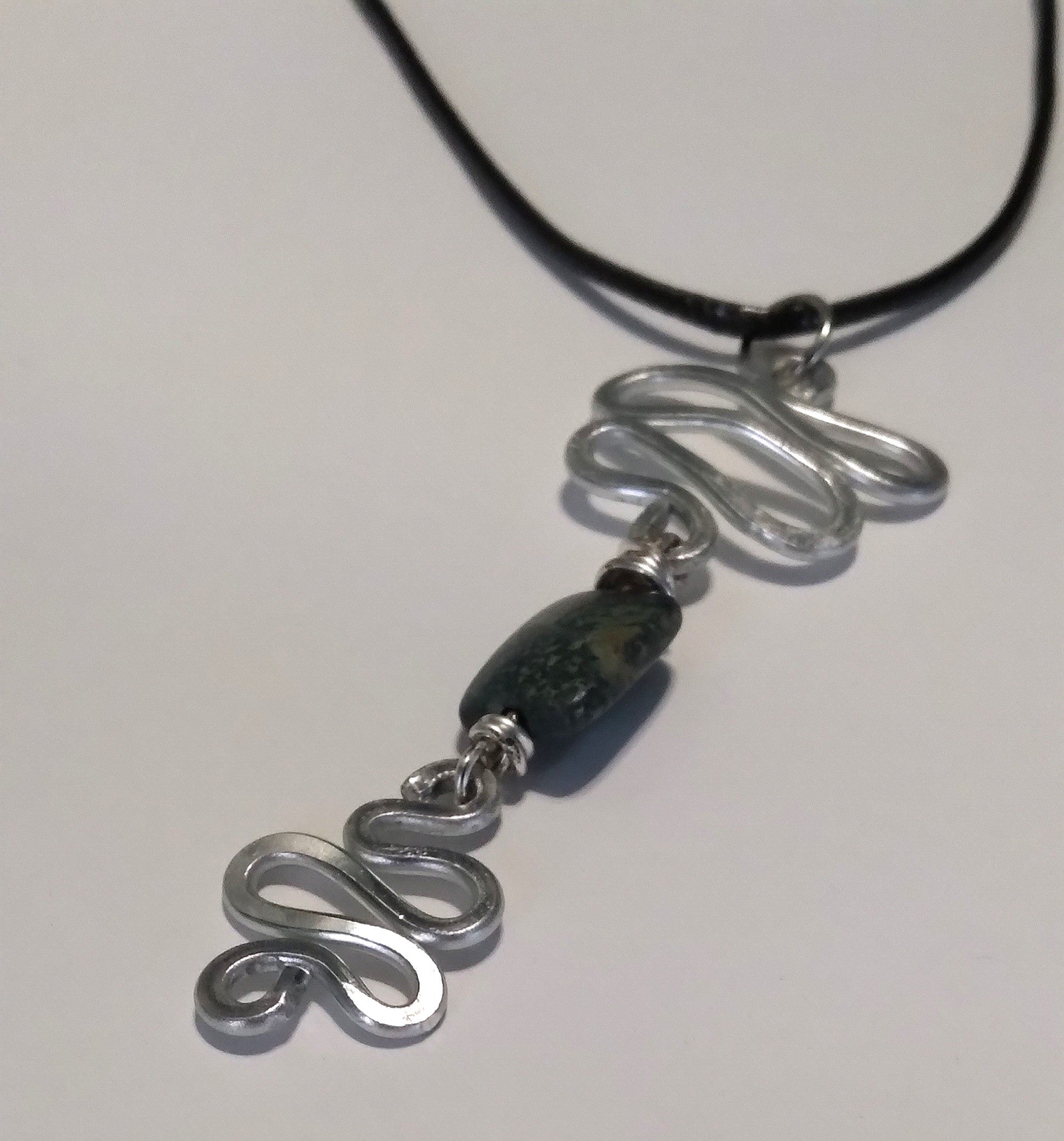 silver aluminium swirl with shades of black centered bead necklace